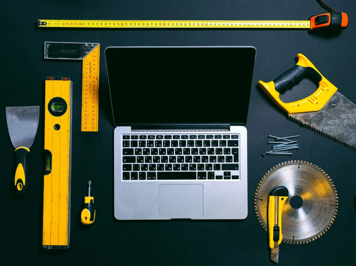 A laptop on a job site showing a pricing article with a cost range table