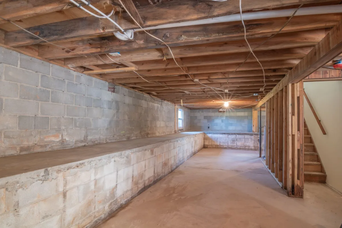 A side by side phone photo of a dirty crawl space next to the same crawl space after encapsulation