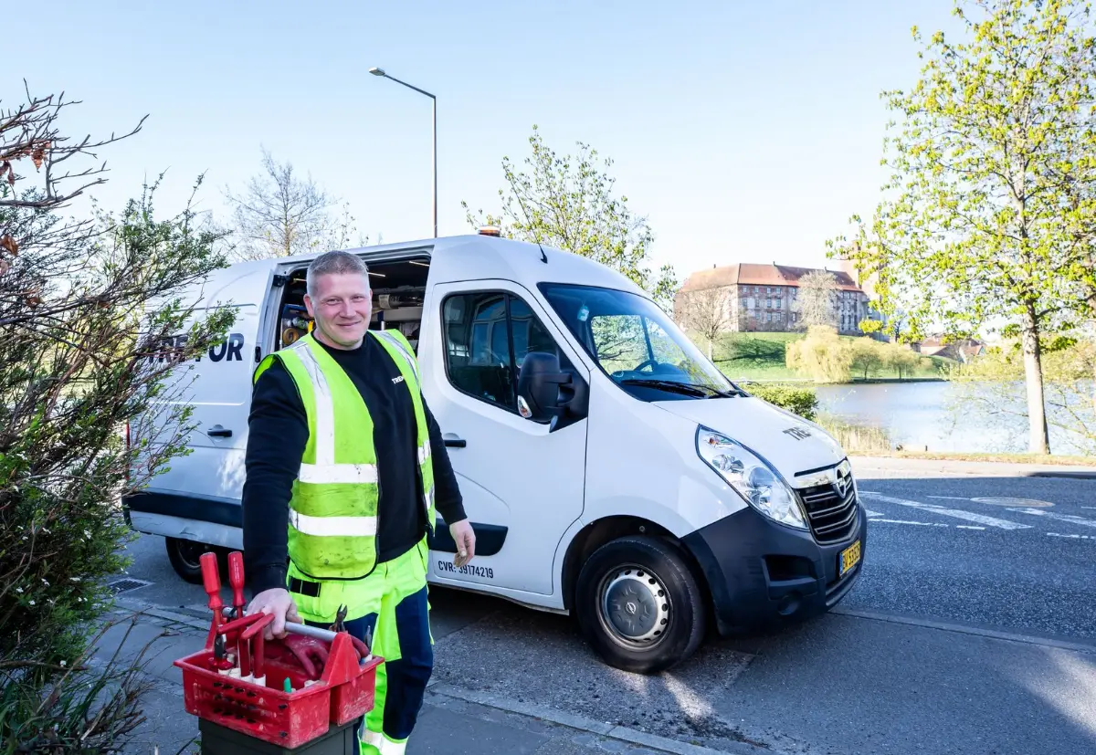 A Facebook hiring ad on a phone screen showing a service technician standing beside a company truck