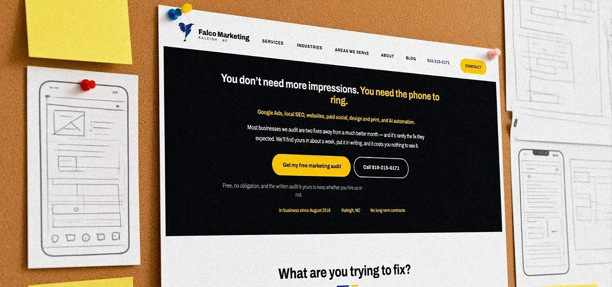 Printed website page mockups pinned to a design wall at Falco Marketing in Raleigh